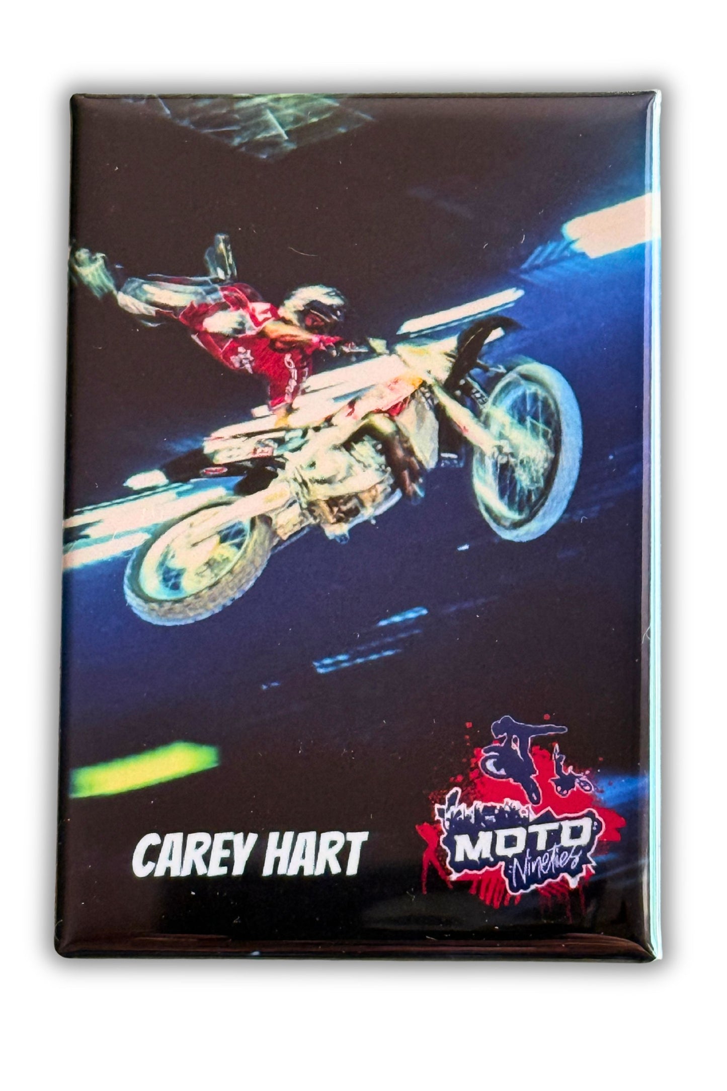 Carey Hart performing a freestyle motocross aerial trick during an indoor motocross event.