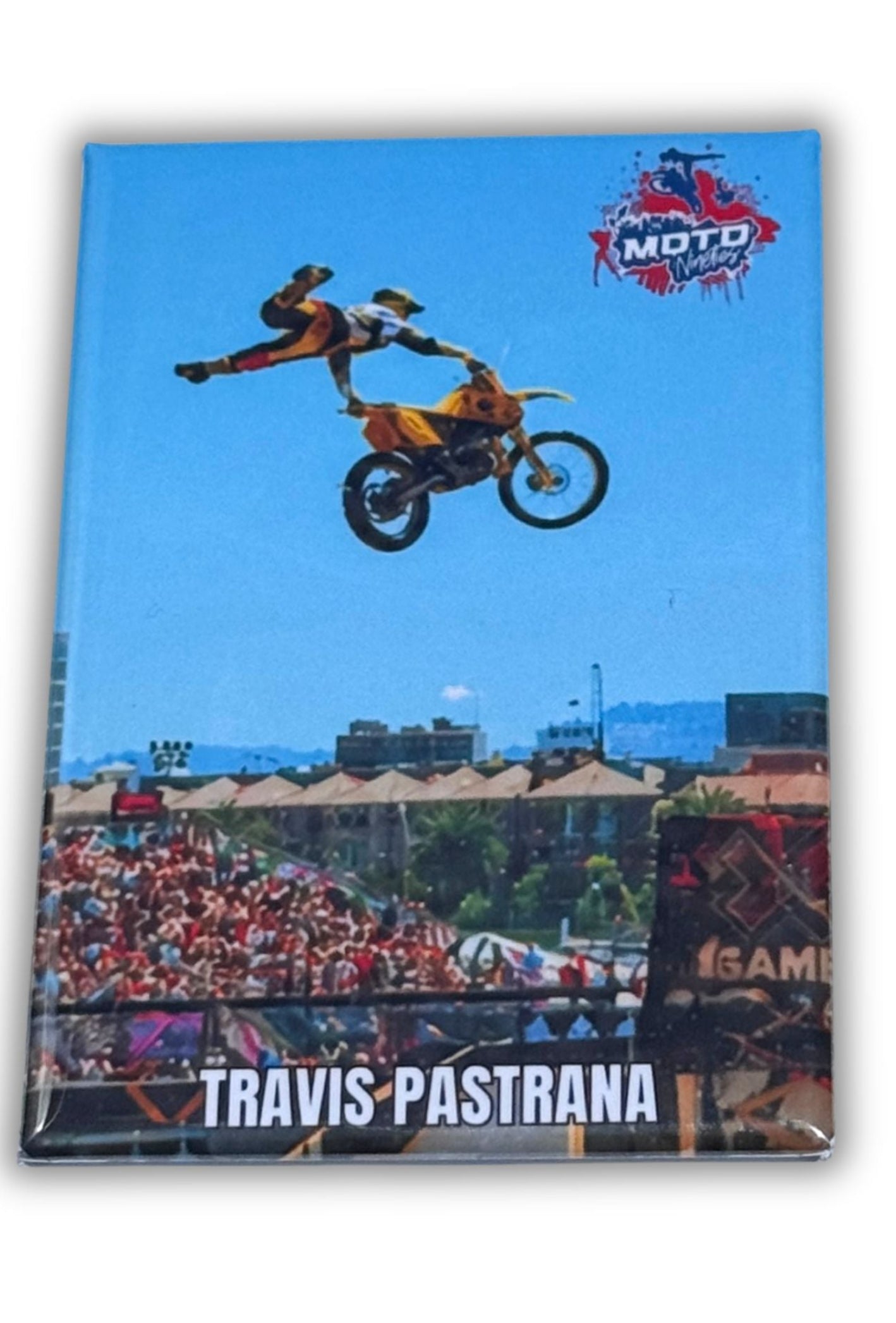 Fridge magnet with a graphic of Travis Pastrana performing a stunt at x Games on a motorcycle against a blue sky, featuring the Moto Time logo.